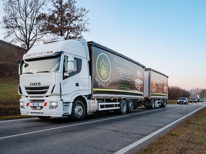 Camion Iveco con logo BRP Legno in transito su strada.