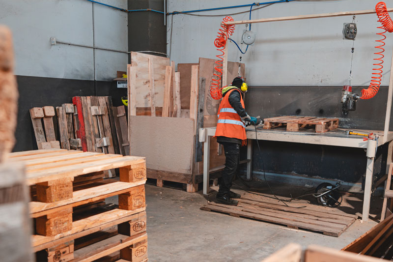 Operaio al lavoro su pallet su misura in laboratorio BRP Legno