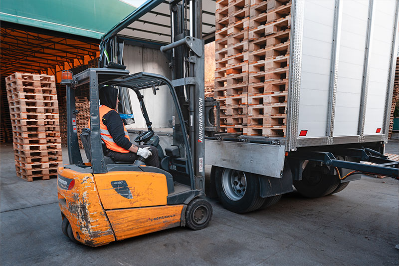 Operatore su carrello elevatore carica pallet su camion BRP Legno