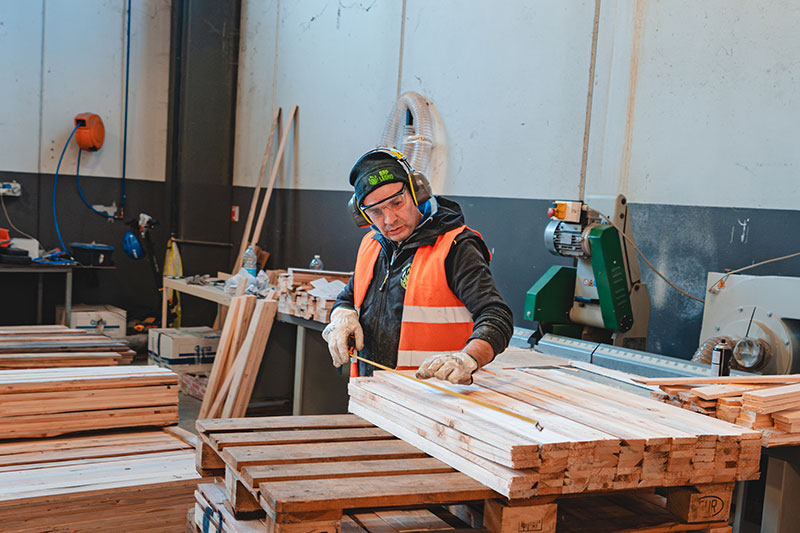 Operaio misura legno su pallet in laboratorio di BRP Legno
