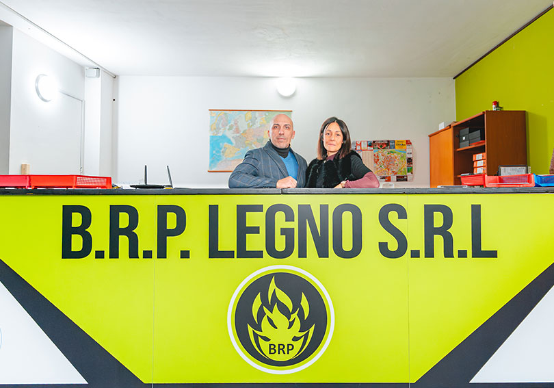 Due persone sorridenti al bancone di BRP Legno S.R.L.