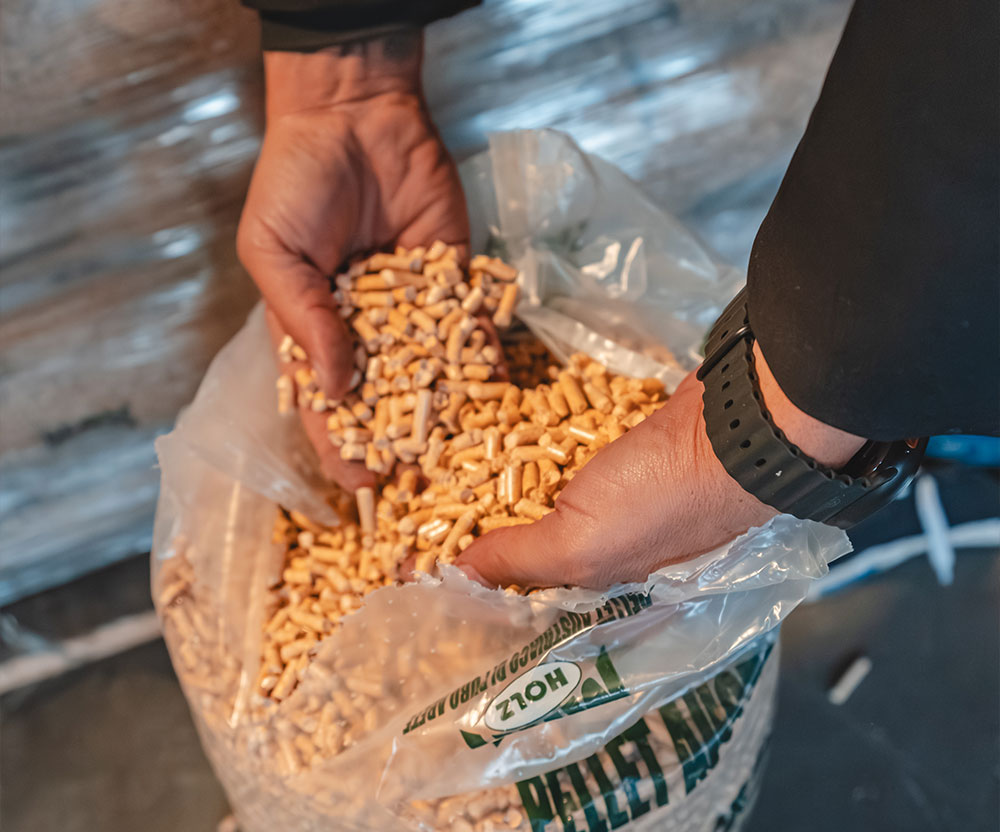 Mani che afferrano pellet da un sacco trasparente BRP Legno